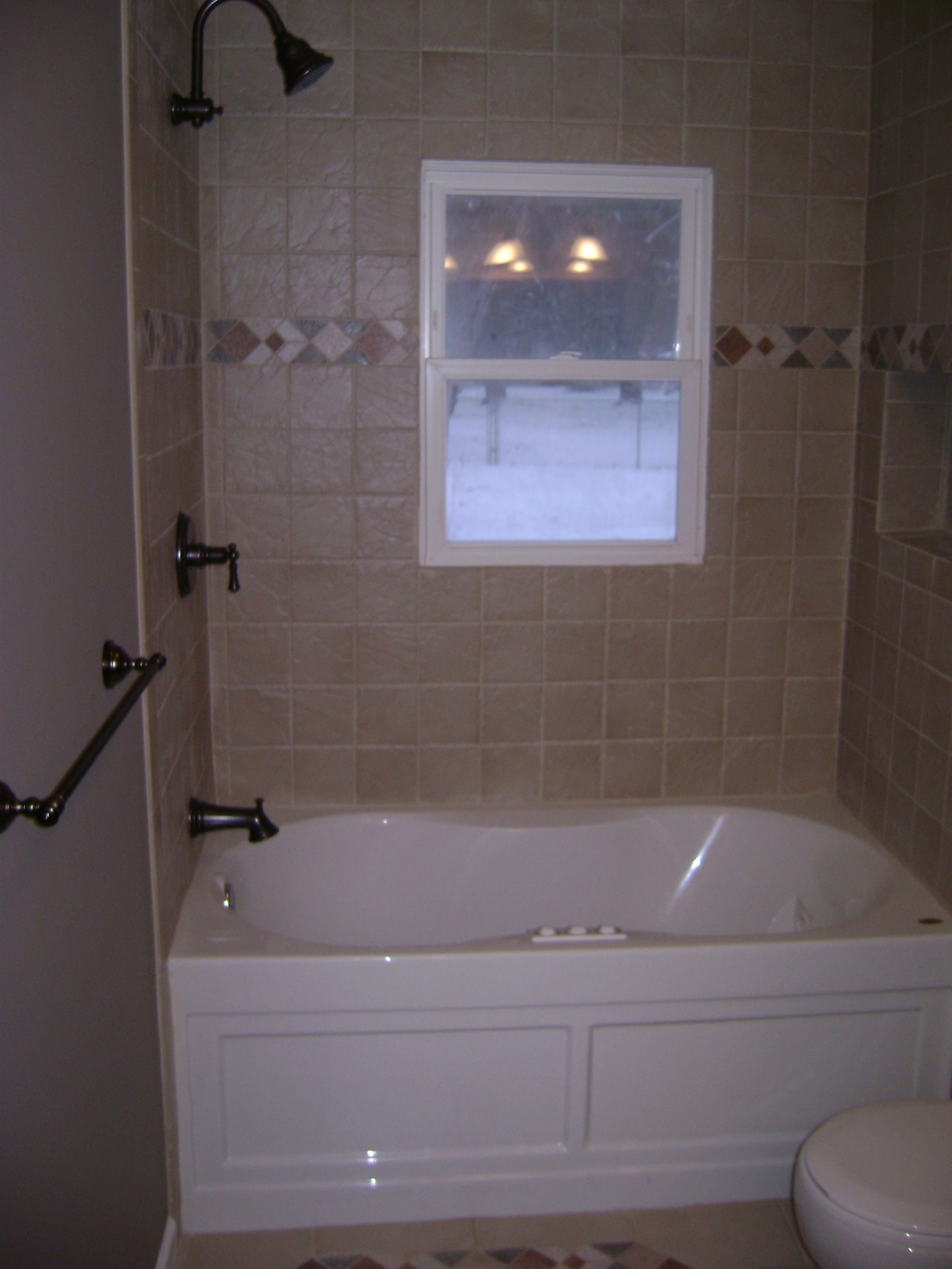 Bathroom renovation with a jetted tub and tiled surround