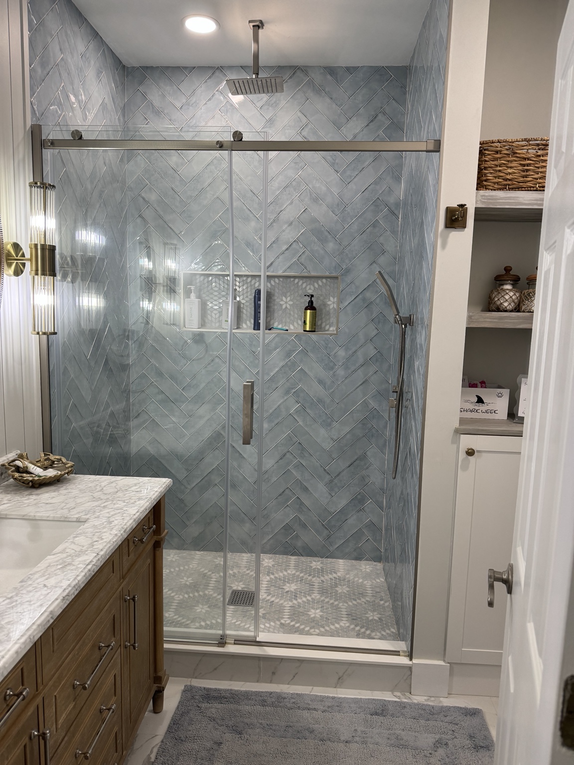 Completed bathroom with a glass-enclosed tiled shower
