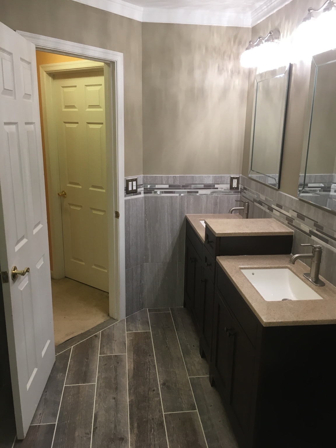 Completed bathroom remodel with tiled shower and dark vanity